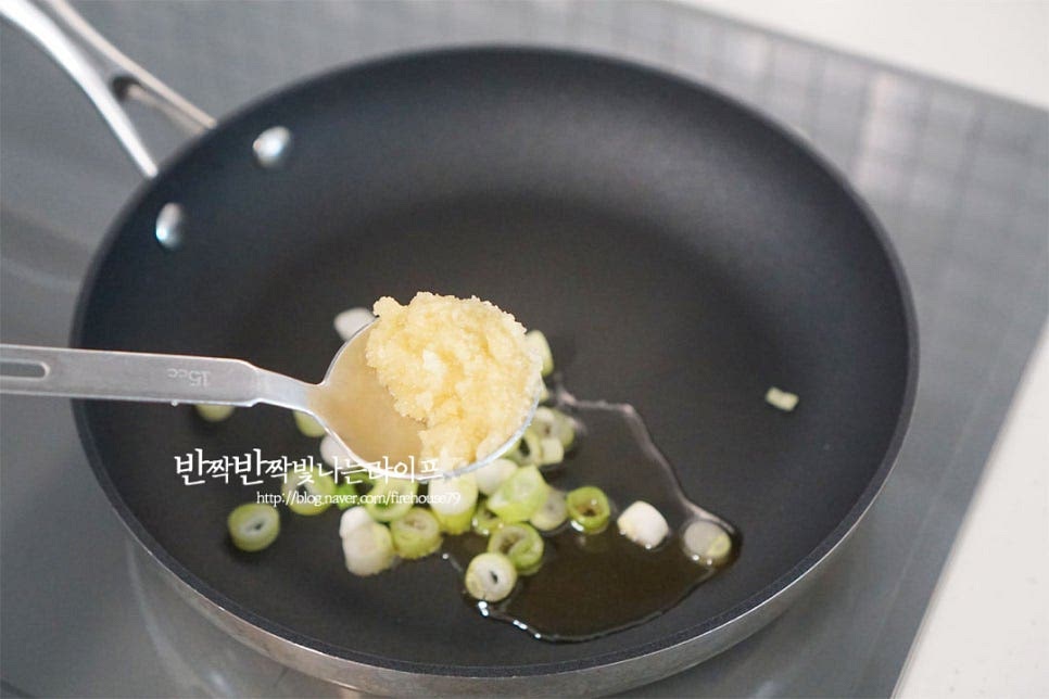 달군 팬에 식용유 1½ 큰 술을 두르고 대파와 간 마늘 2/3 큰 술을 넣어줍니다. 타지 않도록 불을 조절하여 향을 내어줍니다.