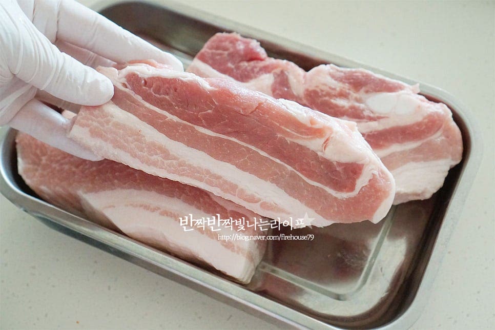 통삼겹은 냄비 크기에 맞게 반으로 잘라서 준비했어요. 쫀득한 식감을 좋아한다면 미박삼겹살이나 오겹살로 만들면 식감이 더 좋습니다. 입맛에 따라 좋아하는 부위를 준비해도 좋고요. 신선한 것은 바로 요리하면 되며 미리 사다 둔 것이라면 차가운 물에 20분 정도 담가 핏물을 제거해 줍니다. 된장 1 큰 술 듬뿍 담아 전체적으로 골고루 발라줍니다. 된장을 물에 풀어서 수육 삶아도 되지만 고기에 발라서 만들면 간도 배고 누린내도 잡을 수 있어요.