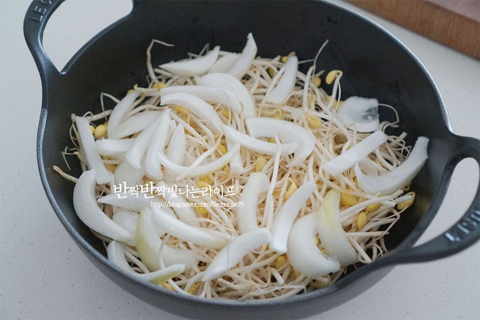 깊이가 있는 팬이나 웍을 준비한 뒤 콩나물과 양파를 먼저 넣어줍니다. 그 위로 대패삼겹살을 올리고 대파와 고추도 함께 올려줍니다. 콩나물을 냄비 바닥에 넣고 먼저 익히면 수분이 나오면서 고소한 대패의 기름이 녹진하게 어우러져 풍미를 살려 만들 수 있습니다. 깻잎은 마지막에 넣고 향긋함을 더해줍니다. 양념까지 올려 푸짐하게 담아줍니다. 볶으면서 재료를 넣어도 되지만 재료를 담은 뒤 식탁 위에 올려 바로 볶아서 먹으면 밖에서 먹는 맛 못지않게 즐길 수 있습니다.