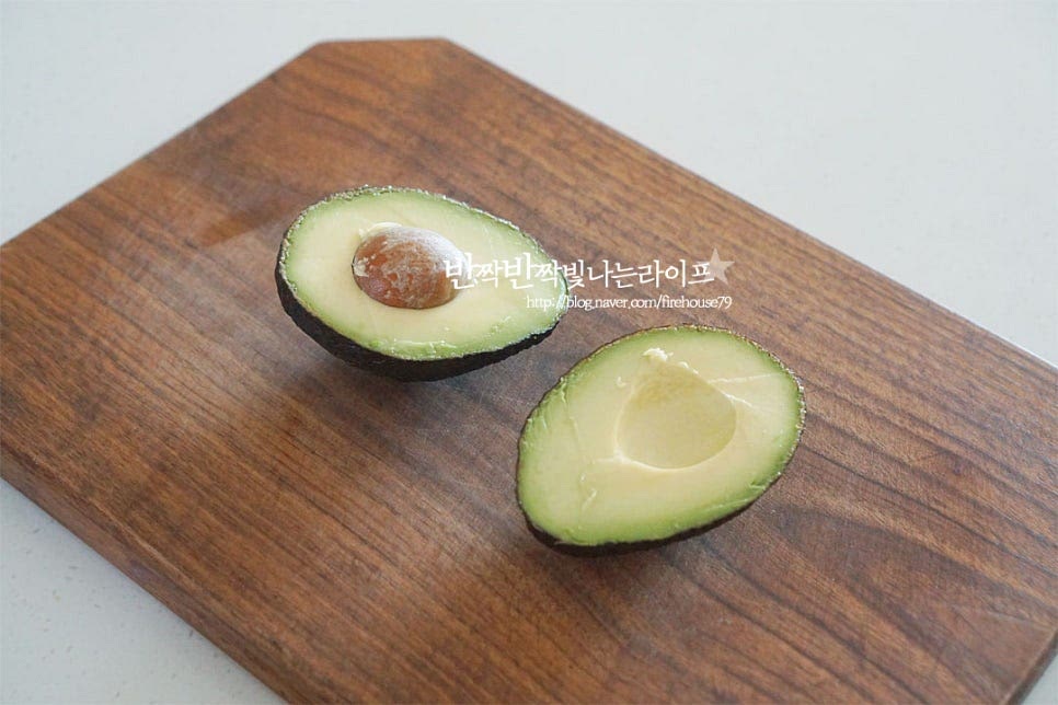 후숙이 잘 된 아보카도는 반으로 잘라줍니다. 후숙하여 먹는 과채로 껍질이 검은색을 띠고 만져보았을 때 말랑하게 되면 특유의 고소함과 부드러움이 요리하기 좋습니다. 가운데를 중심으로 씨에 칼날이 닿도록 칼집을 넣은 뒤 양쪽을 잡고 서로 반대 방향으로 비틀어주시면 아래 사진과 같이 반으로 잘라집니다. 껍질을 벗겨줍니다. 후숙이 잘 되었다면 슥슥 잘 분리되어요. 일정한 간격으로 슬라이스하여 줍니다. 말랑말랑한 상태로 으깨어지기 쉬우니 칼로 자를 때 조심하여 주세요.
