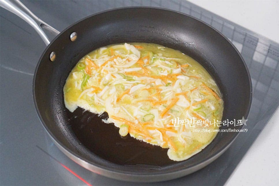 재료를 따로 준비해서 속을 채워도 좋지만 간단한 원팬 레시피로 길거리토스트를 만들어보도록 해요. 먼저 달군 팬에 버터 10g을 녹인 뒤 야채 계란물을 부어줍니다. 그 위로 식빵을 올려줍니다. 달걀이 익기 전에 촉촉한 반숙 정도 일 때 올려주셔야 빵과 고정이 됩니다. 야채 속까지 골고루 익을 수 있도록 불을 약하게 조절하여 구워주세요. 한쪽 면이 익히면 넓은 뒤집개로 뒤집어줍니다. 테두리에 튀어나온 부분은 안으로 접어서 식빵 모양에 맞추어 줍니다. 식빵을 바삭하고 고소하게 굽기 위해 버터 10g을 녹여 구워줍니다. 옛날 맛에 가깝게 굽고 싶다면 마가린을 넣고 구워주세요. 빵을 구우면서 한쪽으로 밀고 햄을 올려서 구워줍니다. 생으로 먹어도 되지만 길거리 감성은 햄도 불판 위에 올려 구워주는 것이죠. 구운 햄은 계란 위로 올려줍니다. 푸짐하게 속을 채워주고 싶어 햄치즈 두 장씩 넣었는데 두께에 따라 한 장씩만 넣어도 좋아요. 그 위로 체다치즈도 올려줍니다.