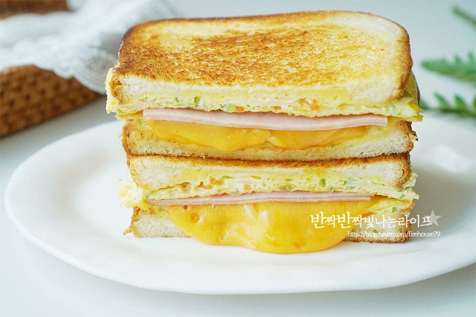 늘어나는 체다치즈를 넣었더니 치즈가 쭉 늘어나면서 맛있게 완성입니다. 겉이 바삭바삭 고소하게 구워지면서 그 사이로 아삭아삭한 식감과 햄치즈의 눅진한 감칠맛, 새콤달콤한 소스까지 맛있게 어울려요. 영상도 같이 담았어요. 갓 구운 식빵 사이로 햄과 치즈만 넣어도 맛있지만 양배추와 야채를 넣은 계란을 구워주면 더 푸짐하고 맛있으며 케첩과 설탕을 뿌려 추억의 맛을 더하면 고소한 그 맛 그대로 완성입니다. 간식으로도 좋고 한끼 식사 대용으로도 딱 좋아요. 간단한 레시피로 맛있는 길거리토스트를 든든하게 요리해드세요. 끄읕 !