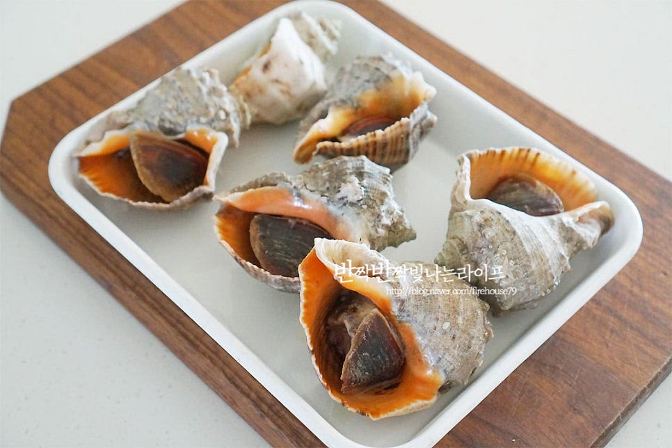 껍데기가 많이 뜨겁기 때문에 펼쳐 놓아 한 김 식혀주었어요. 소라 손질법 포인트는 삶은 뒤 복통과 어지럼증을 일으키는 독소가 있는 침샘을 제거해 주는 것인데요. 먹지 못하는 부분만 잘 제거하여 주면 된답니다. 의외로 먹고 응급실에 가시는 분들이 많으니 침샘은 꼭 제거하여 주셔야 해요. 먼저 손으로 잡아당겨도 좋고, 젓가락을 살에 꽂아 돌려 빼주면 살이 분리되어요. 잘 익었다면 분리가 쏘옥 될 거예요. 입구 부분 껍질은 떼어내어 주고요. 쓸개 부분을 먼저 가위로 잘라 제거하여 줍니다. 진초록으로 까맣게 보이는 부분이 쓸개입니다. 쓴맛이 나기 때문에 제거하여 드심이 좋아요. 살과 내장을 분리한 뒤 침샘으로 제거해 줍니다. 살을 반으로 자르면 노란색 부분이 보이는데요. 이 부분도 깔끔하게 제거하여 줍니다. 살 안쪽의 침샘은 꼭 제거해 주셔야 합니다! 먹기 좋게 썰어 준 뒤 초고추장과 같이 곁들여 주시면 됩니다. 바로 삶아서 먹음 꼬들꼬들 고소한 식감이 더 맛깔나는 것 같아요. 이대로 먹음 바다향이 느껴지고 매콤 새콤한 초고추장에 찍어 먹음 입맛 당기는 별미죠~ 영상도 같이 담았어요. 먹기 좋게 썰어 그릇에 담으니 바다향 가득한 기분이 들죠. 집에서 간단하게 삶아 먹으니 식사는 물론 술안주로도 딱 좋아요. 소라 삶는법 맛있게 식감을 살리고 안전하게 먹는법만 알면 집에서도 바다 내음을 맛보실 수 있어요. 맛있게 만들어 드세요^^