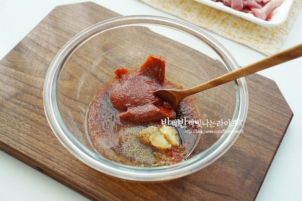 고추장불고기 양념을 만들어요. 고추장 2 큰 술 듬뿍, 고춧가루 3 큰 술 진간장 2 큰 술, 황설탕 1 큰 술 꿀 1 큰 술, 다진 마늘 1 큰 술 듬뿍 맛술 2 큰 술, 생강술(청주) 2 큰 술 참기름 1 큰 술, 후추 약간 넣은 뒤 잘 섞어줍니다. 고추장에 꿀로 단맛을 내어주면 단맛 감칠맛이 더 좋아요~ 없다면 올리고당을 넣어주시고, 간을 보고 입맛에 맞게 가감하여 줍니다. 돼지고기는 키친타월로 핏물을 가볍게 제거해 준 뒤 버무려 줍니다. 골고루 어우러지도록 버무려주었어요.