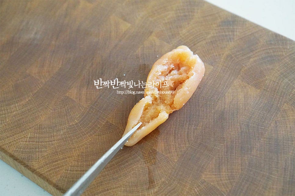 명란젓은 너무 짜지 않은 저염으로 준비했어요. 짠맛에 따라 매실액이나 설탕을 조금 넣고 염분을 줄이고 감칠맛을 더해주셔도 좋아요. 얇은 막 안으로 톡톡 터지는 알이 들어있어 속만 발라내어 무침 해줄 것입니다. 가운데 가위 또는 칼로 칼집을 넣어줍니다. 숟가락으로 살짝 긁어가며 알만 발라내어줍니다. 한 손에 쥐고 칼집을 넣은 부분을 중심으로 알을 발라내면 얇은 막과 분리가 간편합니다.