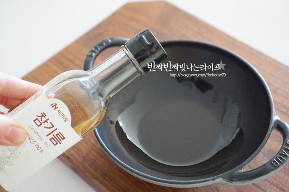 바닥면이 두꺼운 무쇠냄비나 뚝배기에 참기름 1 큰 술 넉넉히 담아줍니다. 참기름을 바르고 밥을 올리면 고소한 풍미도 좋고 맛있게 누룽지가 생긴답니다. 그 위로 밥을 올려줍니다. 신랑이 치즈를 좋아해서 밥 위에 치즈를 올려주었어요. 피자치즈 약간 곁들이면 쭈욱 늘어나는 고소한 맛이 좋아요^^ 이건 취향껏 넣어주심 됩니다. 가장자리로 재료를 담아줍니다. 색을 맞추어 올려주시면 더 먹음직스럽습니다~ 가운데로 날치알을 올려줍니다.