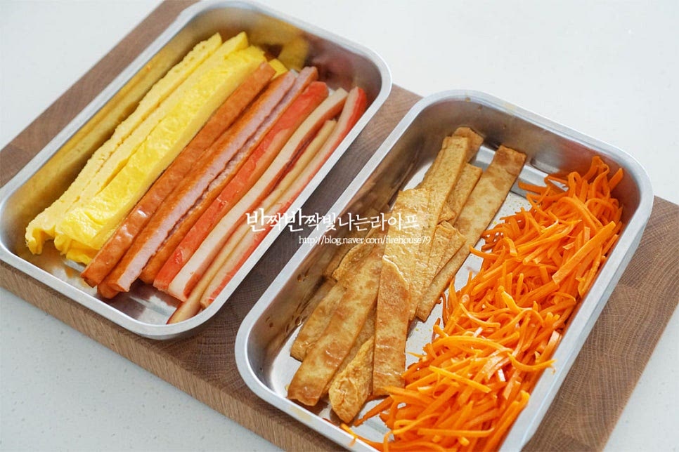 속재료를 김밥 만들기 좋도록 담아줍니다. 김발 위에 김을 올려줍니다. 김의 거친 부분에 밥을 올려 말면 매끈한 부분이 밖으로 나와 말아서 모양내기 좋습니다. 대략 1/2공기의 밥을 올려 뭉쳐지지 않게 넓게 펼쳐줍니다. 김밥 속을 감쌀 정도로 끝부분은 4~5cm 정도 조금 남겨두고 밥을 올리면 됩니다. 그 위로 슬라이스 체더치즈를 올려줍니다. 치즈 염도에 따라 반으로 잘라서 넣어도 좋습니다. 치즈 위로 오이, 맛살, 햄, 단무지 당근, 계란지단, 어묵을 올려줍니다. 동그랗게 모양을 말아줍니다. 아래쪽 김의 끝이 밥 끝 안쪽으로 들어가도록 원통으로 말아주면 됩니다. 김발으로 한 번 더 고정한 뒤 겉에 참기름을 골고루 발라줍니다. 이음새 부분에 따로 밥알을 붙이지 않아도 참기름을 바른 뒤 이음새가 바닥면을 향하도록 잠시 두면 먹기 좋게 고정이 된답니다. 7. 완성 한입에 먹기좋게 잘라 완성합니다. 노란 치즈가 들어가 고소한 맛이 진하고 오독오독 절인 오이의 시원함과 감칠맛나게 어우러지는 속재료가 집김밥의 맛을 완성해 줍니다. 영상도 같이 담았어요. 좋아하는 재료를 넣고 만들 수 있는 김밥은 다채로운 레시피와 맛을 즐길 수 있는데요. 기본이 되는 재료들과 함께 치즈를 넣고 만들면 별미랍니다. 각각 밑간 양념하여 풍부한 맛을 더하면 김과 밥 사이로 어우러져 맛있어요. 언제 먹어도 맛있는 김밥맛있게싸는법 아삭한 오이와 고소한 치즈를 넣고 맛있게 요리해드세요. 끄읕 !