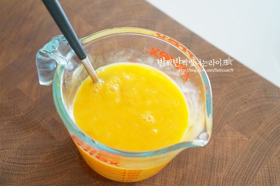 넉넉한 크기에 계란을 넣고 소금 두 꼬집 넣고 곱게 풀어줍니다. 곱게 풀어주면 부드러운 지단을 만들 수 있으며 체에 한번 내려주셔도 좋아요. 달군 팬에 식용유 약간을 골고루 두르고 달걀물을 부어줍니다. 타지 않고 보드랍게 굽기 위해 약불에서 구워줍니다. 두툼한 지단을 구워줄 것이라 양 끝을 계란말이 만들듯이 말아서 두툼하게 구워줍니다. 속까지 익을 수 있도록 약불에서 구웠어요.