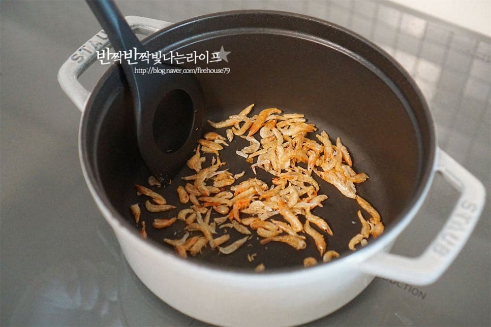 달군 냄비에 건새우를 먼저 가볍게 볶아줍니다. 육수에 넣고 끓여도 되지만 한번 볶아주면 눅눅한 비린내도 잡아주고 고소하고 진한 감칠맛을 살릴 수 있습니다. 타지 않도록 가볍게 볶은 뒤 멸치 다시마 육수를 부어줍니다. 국의 깊고 진한 맛을 살리기 위해 육수 팩으로 간단하게 밑 국물을 내어주었는데요. 쌀뜨물이나 코인육수를 활용해 주셔도 좋습니다. 국물은 대략 1L 정도 부었는데 건더기의 양, 냄비나 화력에 따라 조절해 주세요. 끓어오르면 된장 2 큰 술을 고운 체에 밭쳐 풀어줍니다. 찌개 종류는 그대로 넣어도 되지만 국은 체에 한번 밭쳐 넣어주면 보다 깔끔한 맛을 낼 수 있습니다. 짠맛 염도에 따라 너무 짜지 않게 2큰술 기준으로 조절하여 넣어주세요. 간마늘 1 큰 술, 참치액 1/2 큰 술도 같이 넣어줍니다. 참치액을 같이 넣으면 조금 더 풍부한 감칠맛을 낼 수 있어요. 참치액 대신 국간장을 넣어도 좋은데요. 간에 따라 양을 조절해 주세요.