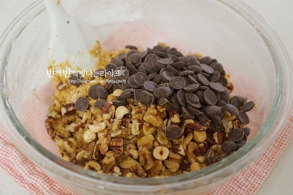 전처리해둔 견과류와 초코칩을 넣어줍니다. 초코칩쿠키는 다크와 밀크를 섞어 넣고 단맛 풍미를 살려줍니다. 고르게 섞은 뒤 하나로 뭉쳐 냉장고에서 1~2시간 휴지해줍니다.