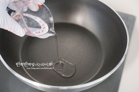 깊이가 있는 팬에 물 1 큰 술, 조청 150g, 물엿 30g, 황설탕 25g, 소금 1g, 무염버터 15g를 넣어줍니다. 조청이 들어가면 너무 달지 않으면서 버터와 함께 부드럽고 촉촉하게 만들 수 있습니다. 중불로 끓여주는데 이때 젓지 않고 그대로 재료가 녹아 어우러지도록 해줍니다. 저으면 단단하게 굳어버릴 수 있으니 그대로 끓여주셔야 합니다. 그대로 두면 갈색빛으로 끓어오르기 시작합니다. 가운데로 투명한 거품이 보글보글 끓으면 퍼핑콩과 준비한 부재료들 넣어줍니다. 눌어붙거나 타지 않도록 주걱으로 저어가며 전체적으로 골고루 버무려 섞어줍니다. 약불로 줄인 뒤 타지 않도록 주의하여 계속 저어서 섞다 보면 수분이 날아가고 끈적이는 거미줄 같은 하얀 끈이 생기고 묵직한 느낌으로 알알이 서로 붙습니다.