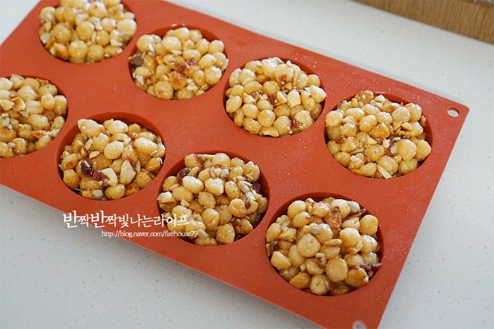 오란다가 굳어버리기 전 뜨거울 때 모양을 잡아줍니다. 베이킹틀이나 사각틀을 활용하여 모양에 맞게 넣고 굳혀줍니다. 동그란틀을 준비하여 재료를 넣고 윗부분이 평평하게 눌러가며 고정될 수 있도록 해줍니다. 틀로 모양을 잡아준 뒤 식힘망에 올려 식혀줍니다. 강정 사각틀에 굳힌 것은 식힌 뒤 먹기좋은 크기로 잘라주면 됩니다. 동그란 베이킹틀에 넣고 굳혀서 자를 것 없이 간단하게 완성입니다.