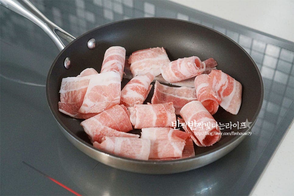 프라이팬에 돼지고기를 올려 노릇노릇하게 구워줍니다. 기름이 많은 부위라 따로 기름을 두르지 않았는데 기름기가 적은 목살이나 앞다리살 같은 경우 식용유를 약간 둘러 구워주시면 됩니다. 노릇하게 익어가면 황설탕 1/2 큰 술 넣어줍니다. 고소한 기름이 달콤한 설탕이 녹아 노릇노릇 구워지면서 풍미가 더 좋아져요. 삼겹살이 구워지면 가장자리로 진간장 3 큰 술 넣어줍니다. 저는 간이 조금 간간한 것 같아 간장량을 줄여 2 큰 술 넣어주었습니다. 간장을 넣고 굽다 보면 눌어붙듯이 달짝지근한 맛이 풍미를 살려주는데요. 갈색빛이 돌게 구워줍니다. 굵은 고춧가루 1½ 큰 술, 간 마늘 1 큰 술 김치 1컵, 물 1/2컵을 넣어줍니다. 양념이 어우러지게 볶아줍니다. 물을 넣고 같이 복아 신 김치에 고기의 고소한 기름이 스며들 수 있도록 해주는데요. 볶음김치 만들다 보면 수분은 자연스럽게 날아가요. 양파, 당근을 넣고 볶아주어요. 대파와 고추를 넣고 불을 끄고 잔열로 익혀줍니다. 가볍게 섞어준 뒤 참기름, 깨소금을 넣고 마무리해요. 앞서 말한 대로 김치의 간에 따라 양념재료를 조절하여 주시면 더 맛있게 드실 수 있어요.