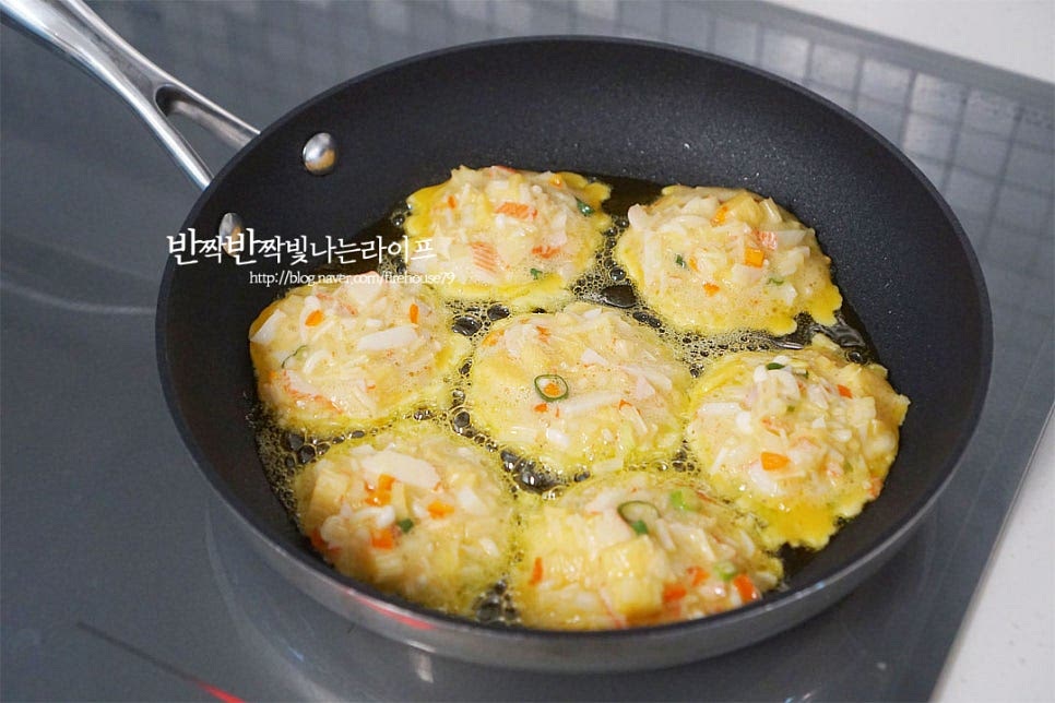 후라이팬을 충분히 예열한 뒤 식용유 넉넉히 둘러줍니다. 팽이버섯전을 구울 때 기름이 적당해야 노릇하고 고소하게 맛볼 수 있으며 속까지 익히기도 좋습니다. 중불에서 동그랗게 반죽을 올려줍니다. 겉이 반숙 이상 익고 바닥면이 노릇해지면 뒤집어 앞뒤로 구워줍니다. 속까지 익을 수 있도록 불을 조절해 부쳐주세요. 앞뒤로 노릇하고 부풀어 올라 속이 익으면 채반에 옮겨 담아 마무리해요.