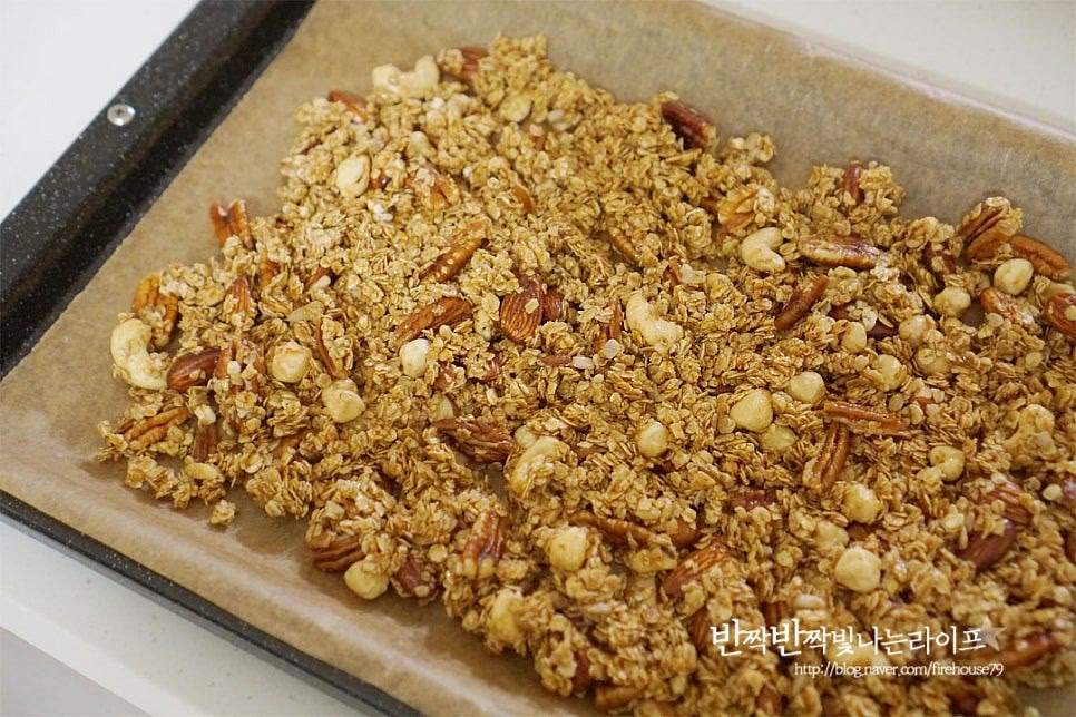 오븐 팬에 넓게 펼쳐 올려줍니다. 수분을 날려가며 식감을 바삭하게 굽고 시럽이 달콤하게 코팅될 수 있도록 해주는 과정이에요. 130도 예열한 오븐에 넣고 130도 15분 구워줍니다. 한 번에 굽는 것이 아니라 골고루 바삭하게 수분을 날릴 수 있도록 세 번에 나누어 구워줄 것이에요. 기기의 사양에 따라 온도와 시간은 조절해 주세요. 1차로 구운 뒤 전체적으로 골고루 섞어줍니다. 중간중간 섞어서 구워주셔야 식감이 더 바삭바삭합니다. 섞은 뒤 2차로 130도 15분 구워줍니다. 마지막 3차로 굽기 전에 말린 과일을 넣어줍니다. 건과일은 마지막에 넣어주세요. 3차 굽기는 130도 10분 구워줍니다. 총 40분 세 번에 나누어 구웠어요. 다시 한번 섞어준 뒤 뜨거운 열기를 식혀줍니다.