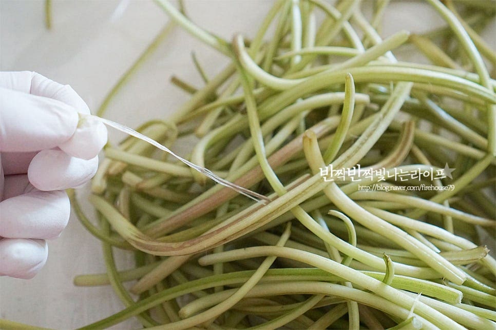 고구마순은 질긴 껍질을 손질한 뒤 요리해주는데요. 끝부분을 살짝 꺾어서 얇은 껍질을 당겨 제거해 줍니다. 손이 검게 물들 수 있어 장갑을 끼고 다듬는 게 좋으며 손질된 것을 준비해도 간편합니다. 손질 후 대략 250g 정도입니다. 손질하면서 저는 먹기 좋은 길이로 자른 뒤 물에 담가 세척해 물기를 털어주었습니다. 삶은 뒤 한 입 크기로 잘라주셔도 됩니다.