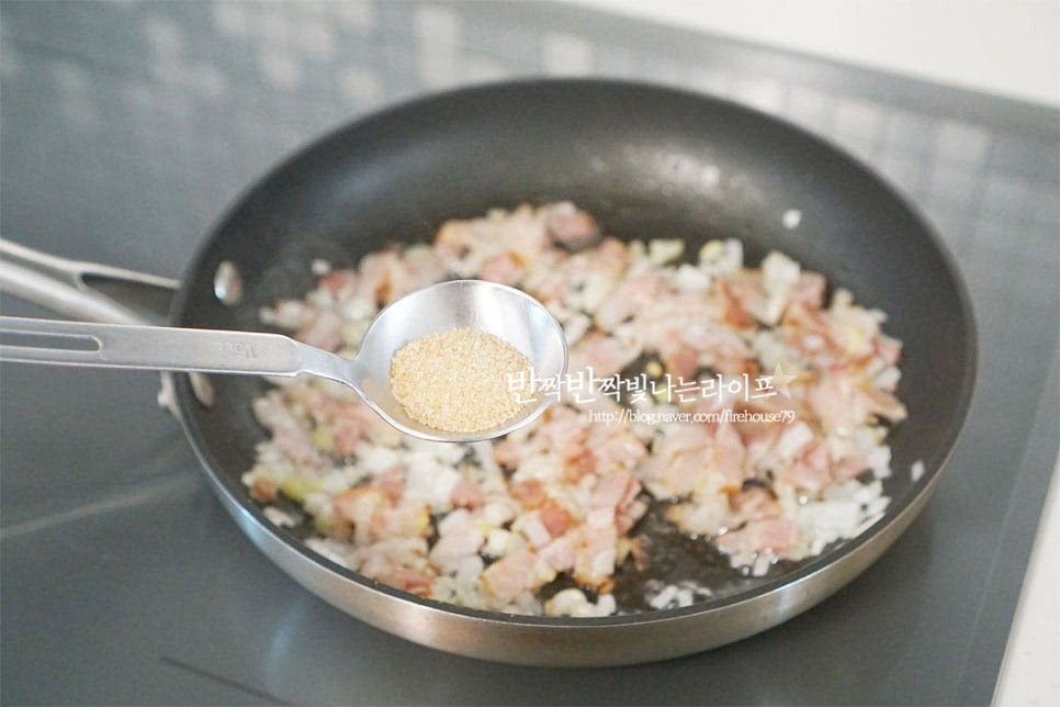 베이컨이 노릇하게 볶아지면 황설탕 1/3 큰 술을 넣고 눌어붙게 볶아줍니다. 신맛에 설탕을 넣어 새콤함을 중화시키고 감칠맛을 살려주는 것인데요. 숙성 정도에 따라 설탕량은 가감하여 주셔도 좋습니다. 설탕이 녹으면 진간장 1/2 큰 술을 넣어줍니다. 수분이 사라지도록 향을 내어 볶은 뒤 잘게 썬 김치를 넣어줍니다. 고운 고춧가루 1/3 큰 술도 넣어줍니다. 타지 않도록 중약불에서 볶으면서 양념재료가 뭉치거나 수분이 부족하면 물을 조금 추가하여 볶아주셔도 좋습니다.