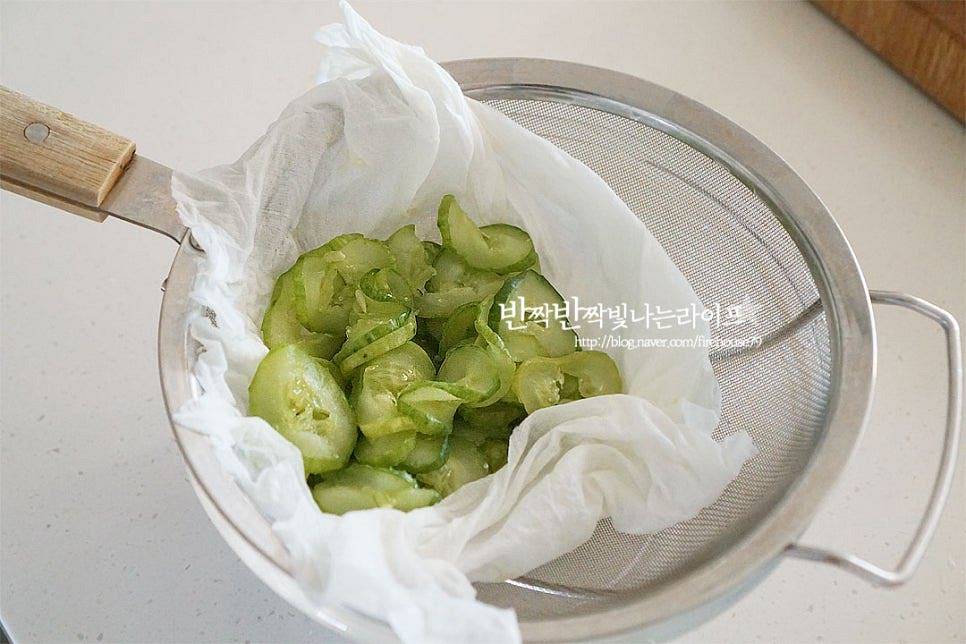 절인 오이는 면포로 물기를 꼭 짜줍니다. 짠맛에 따라 한번 헹구어 물기를 짜주어도 좋아요. 달군 팬에 참기름 1 큰 술을 두르고 절인 채소를 볶아줍니다. 수분을 날려 고소하게 볶아 익혀줍니다.