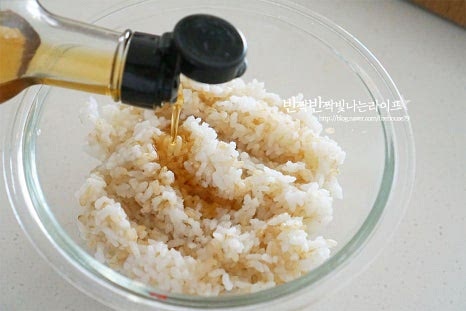 밥 한 공기 넉넉하게 담고 소금 한 꼬집, 참기름 1 큰 술 깨소금 1 작은 술을 넣어줍니다. 주재료인 스팸이 짠맛이 있기 때문에 전체적으로 재료에 약간만 간을 해주어 조화롭게 어우러지도록 해줍니다. 고슬고슬 밥알이 뭉치지 않게 섞어줍니다.