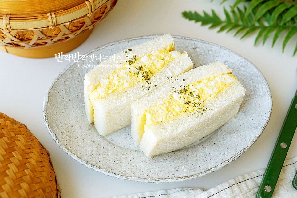 반으로 자른 뒤 가운데 파슬리가루를 약간 뿌리면 맛있는 에그마요샌드위치만들기 완성입니다. 고소함과 부드러운 식감에 아이들 간식으로도 좋고 든든한 한 끼 식사로도 든든합니다. 계란을 완숙 삶는 시간에 맞추어 촉촉하게 삶은 뒤 노른자와 흰자를 분리해 으깬 뒤 마요소스에 버무리면 간단하게 레시피 완성입니다. 맛있게 만들어드세요. 끄읕 !