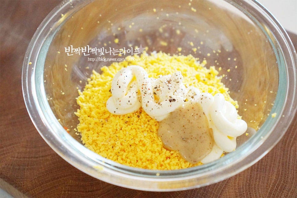 곱게 으깬 노른자에 소스 재료를 넣어줍니다. 마요네즈 4 큰 술, 허니 머스터드 1/2 큰 술 알룰로스 1/2 작은 술, 소금과 후추 약간 넣어주세요. 뭉치지 않고 섞이도록 버무려줍니다. 노른자부터 섞어주면 비린 맛과 텁텁함 없이 부드럽고 촉촉한 식감으로 만들 수 있어요. 잘게 으깬 흰자도 넣고 버무려주세요. 간에 따라 소금, 후추를 더해주고 마요네즈로 농도를 조절해 주는데요. 마요네즈를 줄이고 싶다면 플레인 그릭요거트를 넣어주셔도 좋습니다.