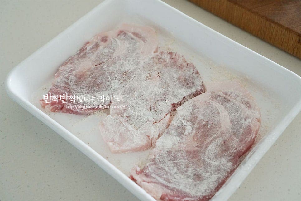 밑간 시즈닝 해둔 돼지목살에 밀가루를 뿌려 골고루 입혀줍니다. 밀가루옷을 입혀서 구우면 모양이 예쁘게 구워지고 육즙이 새어나지 않고 보존되어 식감이 더 부드럽고 촉촉합니다. 그리고 소스의 농도를 걸쭉하게 조절해 주고요. 달군 팬에 식용유를 넉넉하게 두르고 마늘과 함께 구워줍니다. 두께에 따라 속까지 잘 익을 수 있도록 기름 양은 조절해 주세요. 타지 않도록 중불에서 굽습니다. 핏물이 올라오면 앞뒤로 뒤집어 구워주세요. 초벌로 굽는 조리과정으로 겉이 하얗게 익고 핏기가 없는 정도로만 익혀주세요. 초벌한 재료를 따로 덜어두고 프라이팬을 정돈한 뒤 버터 1 큰 술을 녹입니다. 버터 향이 스며들도록 해서 고소한 풍미를 끌어올려 앞뒤로 노릇하게 구워줍니다. 버터는 타기 쉬우니 뒤집어가며 익혀주세요. 노릇해지면 덜어두고 버터가 있는 그대로 양파를 넣고 볶아줍니다. 양파가 투명해지면 만들어둔 소스를 넣고 새콤한 식초의 향을 날린 뒤 물 1/2컵을 부어줍니다. 화력이나 농도에 따라 물의 양은 조절해 주세요. 물을 넣으면 간이 약간 싱겁지만 수분을 날려 졸일 것이라 그 정도가 좋습니다. 바글바글 끓으면 넣고 졸입니다. 밀가루옷을 입혀 간이 더 잘 배고 농도가 걸쭉하게 조절되어 졸여집니다.