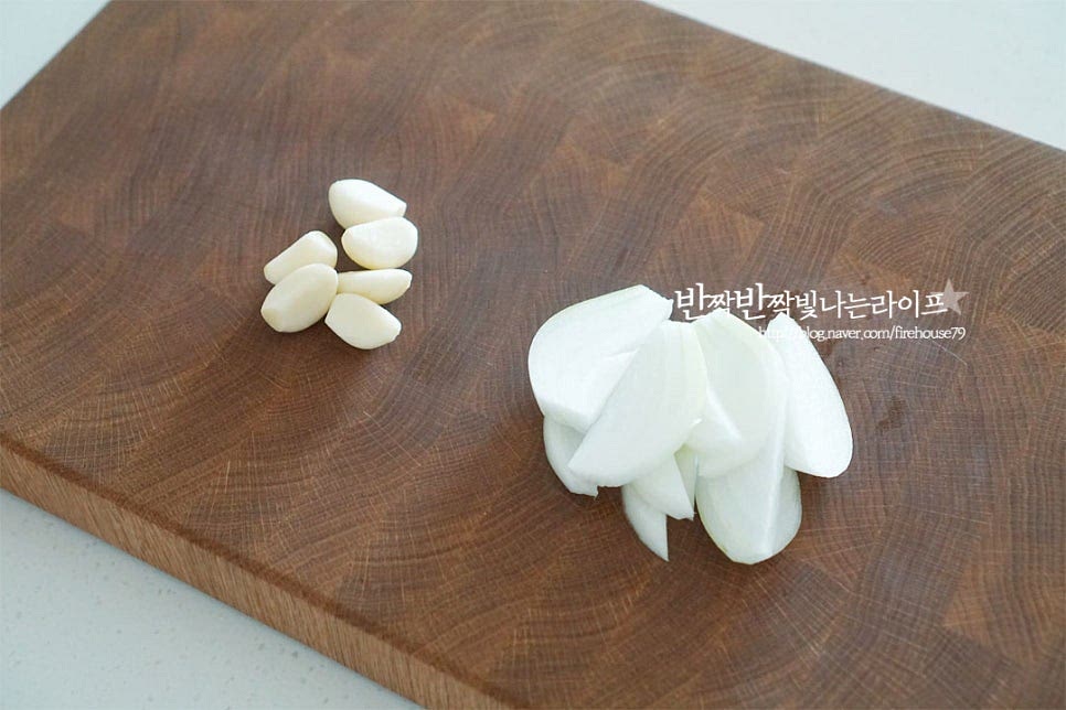 스테이크에 곁들일 채소로 마늘과 양파를 준비했어요. 마늘은 꼭지를 제거하고 통으로 준비하고 양파는 채를 썰어줍니다. 소스에 양파를 추가로 넣어주었는데 버섯이나 파프리카 같은 야채를 넣어도 좋습니다.