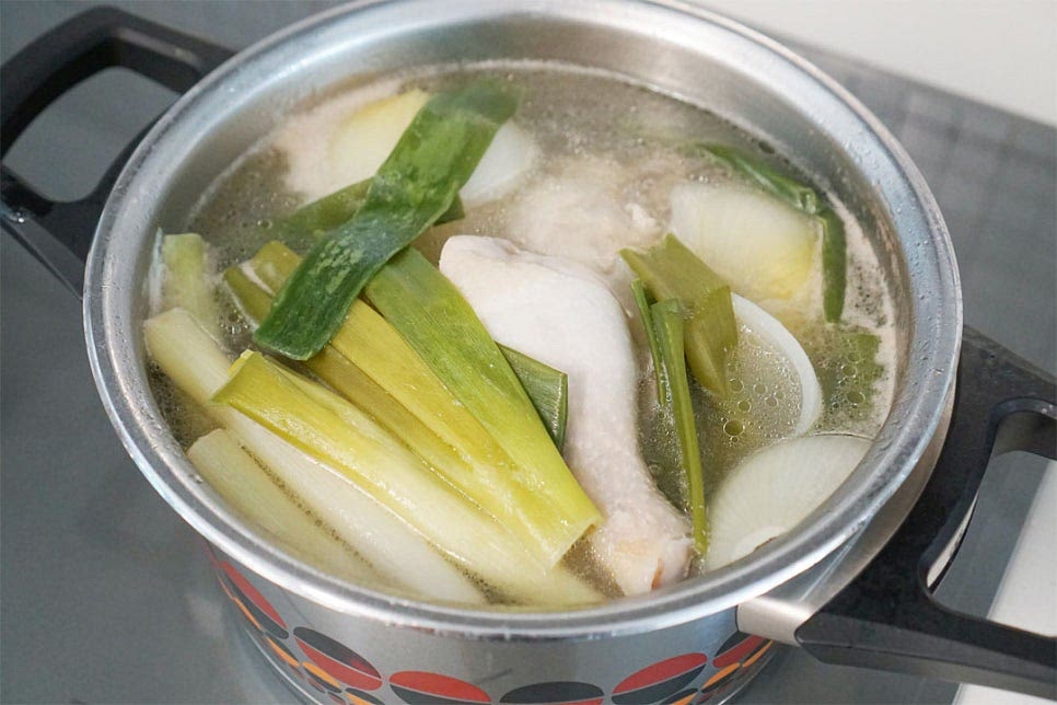 10분 이상 끓이면 적당하게 익고 뽀얗게 국물이 우러나있어요. 그럼 전골냄비에 담아 야채와 함께 끓여줄 것이에요. 닭고기는 건져서 옮겨 담아줍니다. 국물은 밑간을 해주는데요. 소금 1 큰 술, 후추 약간 넣고 간을 맞춘 뒤 불순물 없이 깔끔하게 채반에 면포를 올려 국물을 걸러서 부어줍니다.