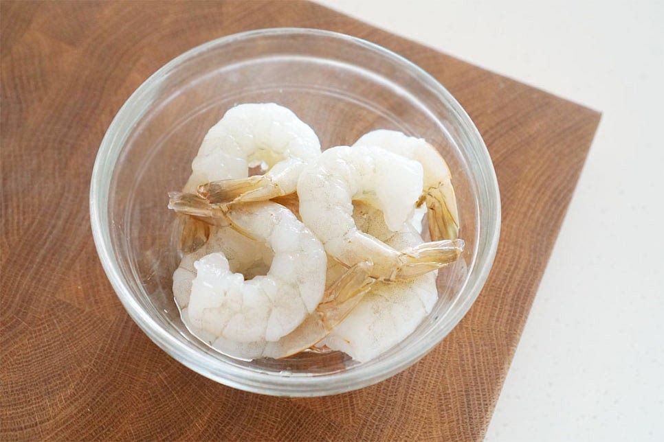 손질된 새우를 10마리 정도 준비했어요. 냉동 소분해 두었던 것이라 해동 후 흐르는 물에 세척해 물기를 제거해 주었습니다. 바질페스토는 바질잎으로 잣을 넣고 만들어 소분해두었던 것을 4 큰 술 덜어주었습니다. 진하기 정도에 따라 양을 조절해 준비해 주세요. 양파는 밥알의 식감과 어우러지도록 잘게 다져 썰어주었습니다. 그 외 베이컨이나 버섯, 닭 가슴살 등 취향에 따라 좋아하는 재료를 준비해 주세요.