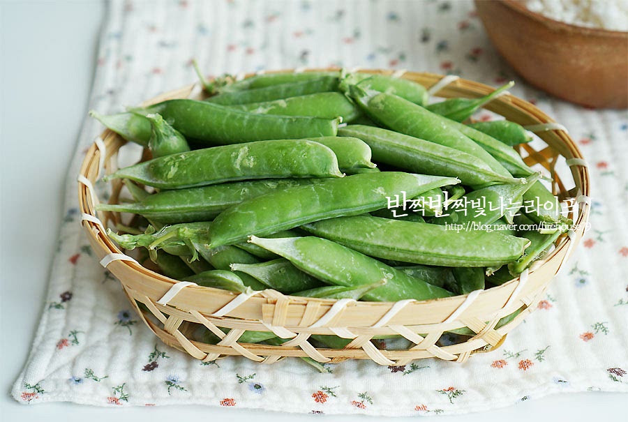 콩을 손질하여 줍니다. 한창 제절에 접어들어서 마트나 시장에 가면 망에 들어 파는 걸 보실 수 있으실 거예요. 저도 한 망 사 왔어요. 망을 열어보면 아래와 같이 꼬투리 채 들어있어요. 삶아 먹을 때는 이대로 요리하지만 밥에 넣어 먹을 것은 알알이 손질을 해주어야 합니다. 가운데에 보면 이음새가 보이는데요. 꼭지 부분의 이음새를 따라서 가운데를 갈라보면 이렇게 콩이 들어있어요. 만졌을 때 통통한 것은 알알이 여물게 가득 차 있어요. 한 망에서 1/3 정도는 밥을 지을 것이고 나머지는 소분해둘 것이라 모두 분리하여 주었어요. 완두콩 보관은 밥에 넣어 먹을 것은 알알이 소분하여 밀폐용기나 지퍼백에 담아 냉동 보관해 줍니다. 삶거나 쪄 먹을 때는 꼬투리 채 보관을 하셔야 하는데요. 그럴 땐 껍질째 신문지에 돌돌 말아 야채 칸이나 김치냉장고에 넣어주세요. 단, 오래 두면 신선도가 떨어지니 가급적 2~3일 내로 드시는 게 좋아요.