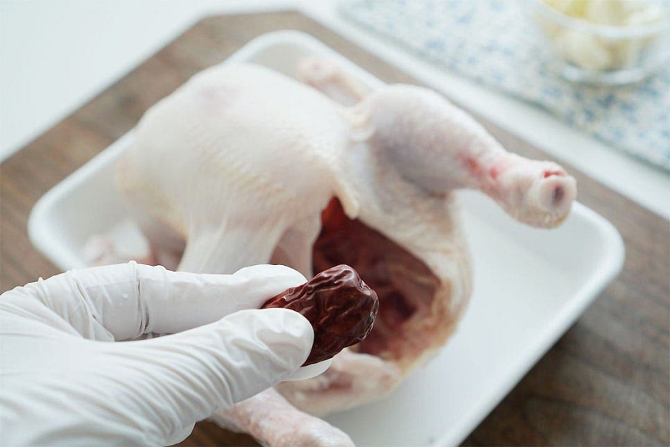 몸통에 대추, 밤, 찹쌀을 넣어줍니다. 속에 넣은 재료는 목과 엉덩이 부분으로 새어나지 않게 넣어주면 되는데요. 안쪽으로 대추를 먼저 넣어줍니다. 목뼈를 안쪽으로 밀어 넣으면 재료가 새어나지 않아요~ 그리고 불린 찹쌀 반컵을 넣어주어요. 찹쌀은 30분 정도 미리 불려두었어요. 찹쌀의 쫀득함이 어우러진 누룽지 요리는 식감이 부드러워 더 맛있어요^^ 찹쌀이 새어나지 않도록 깐 밤을 넣어주었어요. 이쑤시개나 나무 꼬치로 엉덩이 부분을 고정해 줍니다. 한쪽 다리에 칼집을 넣고 엇갈리게 꼬아 주어도 되는데 꼬아준 다리는 끓으면서 풀어지기 쉬워 재료가 새어나지 않게 끓이고 싶다면 이쑤시개로 고정해 주심 됩니다.