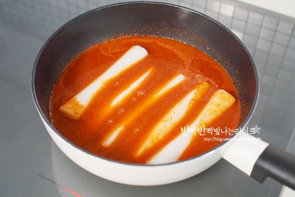 끓어오르면 가래떡을 넣어줍니다. 눌어붙지 않게 살살 저어가며 끓여줍니다. 1분 정도 끓이다가 썰어둔 어묵과 삶은 계란도 함께 넣어요. 말랑말랑한 떡이라 양념만 졸이면 되어 재료를 한 번에 넣었습니다.