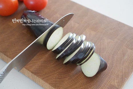 라따뚜이의 기본 야채로 가지, 호박, 토마토를 준비했어요. 좋아하는 종류의 다른 채소를 곁들여도 좋습니다. 세 가지 모두 깨끗하게 세척하여 물기를 제거해요. 재료 본연의 둥근 모양을 살려 0.5cm 두께로 썰어줍니다. 양 끝 부분은 모양이 일정하지 않아 따로 담아두어 소스를 만들 때 넣어줍니다. 토마토도 동일하게 0.5cm로 잘라줍니다. 너무 두껍지 않게 썰어주어야 오븐에 함께 구웠을 때 식감도 좋고 풍미를 어우러지게 맛볼 수 있습니다. 동그란 단면으로 자르기 때문에 지름이 비슷하면 모양을 내기도 좋습니다. 색깔을 살려 겹치지않게 담아주면 보기에 먹음직스러우므로 하나씩 번갈아가며 담아둡니다. 토마토의 산뜻함과 애호박, 가지의 고소한 구운 맛이 잘 어울려 맛있어요.