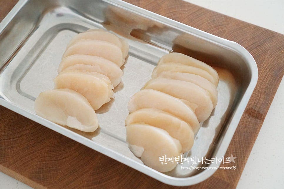 먹기 좋게 요리할 수 있도록 관자만 손질된 것을 준비했어요. 적당한 두께로 슬라이스 된 것인데 두껍다면 적당하게 잘라주셔도 좋습니다. 겉의 테두리 부분을 보면 얇은 막이 보이는데요. 그 부분은 식감이 질길 수 있어 살짝 돌려서 제거해 줍니다. 손질 후 흐르는 물에 가볍게 헹구어준 뒤 물기를 제거해주세요. 부드러운 식감과 버터 향이 스며들 수 있도록 칼집을 넣어줍니다. 깊게 칼을 넣으면 갈라질 수 있으니 겉에만 살짝 모양내어주세요.