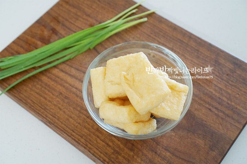 유부주머니부터 만들어보아요. 사각 유부를 준비했습니다. 건당면은 미리 찬물에 30분 이상 불려두었습니다. 불린 당면을 바로 넣고 만들었는데 미리 불리지 못했다면 데쳐 준비해 주시면 됩니다. 당면은 잘게 송송 썰어주어요. 볼에 자른 당면과 다진 돼지고기, 다진 대파 1 큰 술, 진간장 1 큰 술 황설탕 1 작은 술, 다진 마늘 1/2 작은 술 소금과 후추 약간, 참기름 1/2 작은 술 넣어줍니다. 들어가는 재료는 간단하게 준비해 주었는데 두부, 버섯, 당근 등 다양하게 넣으시면 됩니다. 간은 달짝지근하게 맞추어 주시면 됩니다. 바로 재료를 넣고 만드셔도 좋고 남는 잡채가 있다면 잘게 썰어서 넣어주시면 훨씬 만들기 간편합니다. 유부는 끓는 물에 2~3분 정도 데쳐줍니다. 데쳐서 만들어 주셔야 가운데 속이 잘 분리되며 튀긴 재료의 기름을 제거할 수 있습니다. 찬물에 헹구어 물기를 제거해 줍니다. 물기를 제거하여 기름도 빼줍니다. 정수기의 뜨거운 물을 받아 부추를 살짝 담가 데쳐주었습니다. 작은 양을 만들 땐 끓는 물에 데치지 않고 이렇게 준비해 주시면 보다 간단하게 요리할 수 있어요. 유부 끝부분을 잘라내고 가운데 속을 벌려 속 재료를 넣어줍니다. 2/3 정도 속을 채운 뒤 데친 부추로 입구 부분을 묶어줍니다. 하나둘 반복하여 만들어 줍니다.
