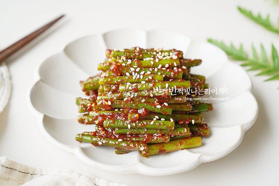푸짐하게 담은 뒤 통깨 약간 뿌려주면 맛있게 완성입니다. 영상도 같이 담았어요. 마늘쫑은 알싸한 매운맛이 맛있지만 생으로 먹으면 아린맛이 느껴질 수 있는데 가볍게 소금을 넣고 살짝 데친 뒤 매콤 달콤한 고추장양념에 무치면 보드라운 식감과 향미를 맛볼 수 있어요. 간단하고 맛있는 레시피로 요리해드세요. 끄읕 !