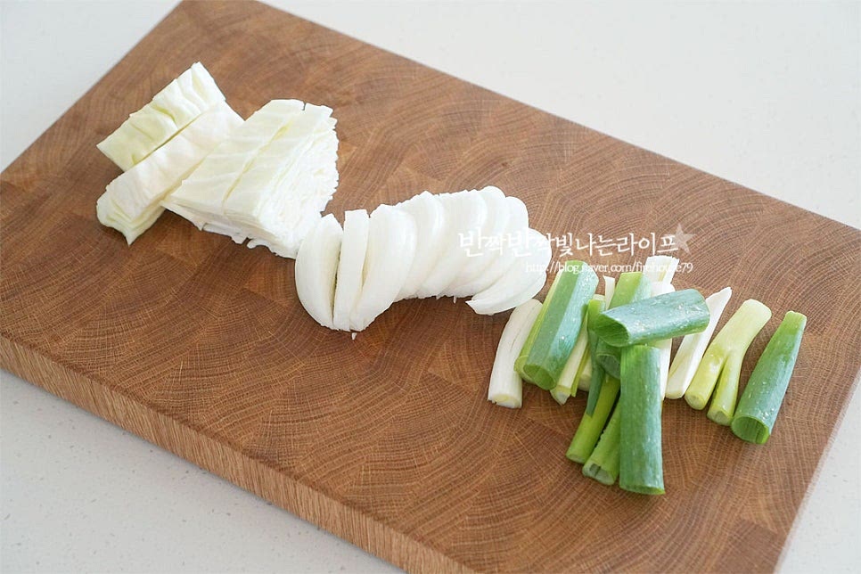 대파는 흰 대 부분은 길게 반으로 잘라주고 길게 6cm 길이로 잘라줍니다. 양배추는 결 반대 방향으로 자르고 양파는 0.5cm 두께로 썰어줍니다. 양배추의 아삭한 식감을 좋아해서 조금 굵게 썰어주었는데 조금 더 얇게 0.5cm로 잘라주면 됩니다. 청양고추는 0.3cm 두께로 송송 썰고 깻잎은 반으로 가른 뒤 1cm 너비로 썰어줍니다. 매운맛 기호에 따라 고추를 더해주고 깻잎은 향긋하게 조금 넉넉히 넣어도 좋을 것 같습니다. 시판용 순대를 활용하면 집에서도 푸짐하게 요리할 수 있죠. 냉장고에서 꺼내어 주었습니다. 기본 양은 1/2팩인 250g 기준인데 양념장이 넉넉한 편이라 300g을 준비했습니다. 순대는 두께 1.5cm로 썰어줍니다. 너무 가늘고 얇게 썰면 요리하면서 속이 터질 수 있어 도톰하게 잘라주는 게 좋습니다. 두툼하고 쫄깃한 식감이 야채와도 잘 어울리고요.