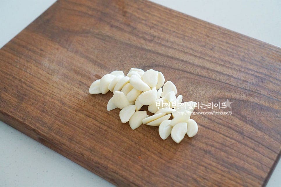 풍미를 더해줄 마늘과 고추를 준비했어요. 마늘을 넉넉히 넣어 풍미를 살려주는 게 특징인데요. 마늘이 확실히 많이 들어가는 게 맛과 풍미가 좋아요. 중간중간 같이 먹음 정말 맛나요~ 마늘은 조금 두툼한 편으로 썰어줍니다. 마늘은 꼭 들어가는 재료이고 고추는 매운맛 기호에 따라 같이 곁들여 주시면 됩니다. 저는 색깔별로 하나씩 큼직하게 썰어주었어요.