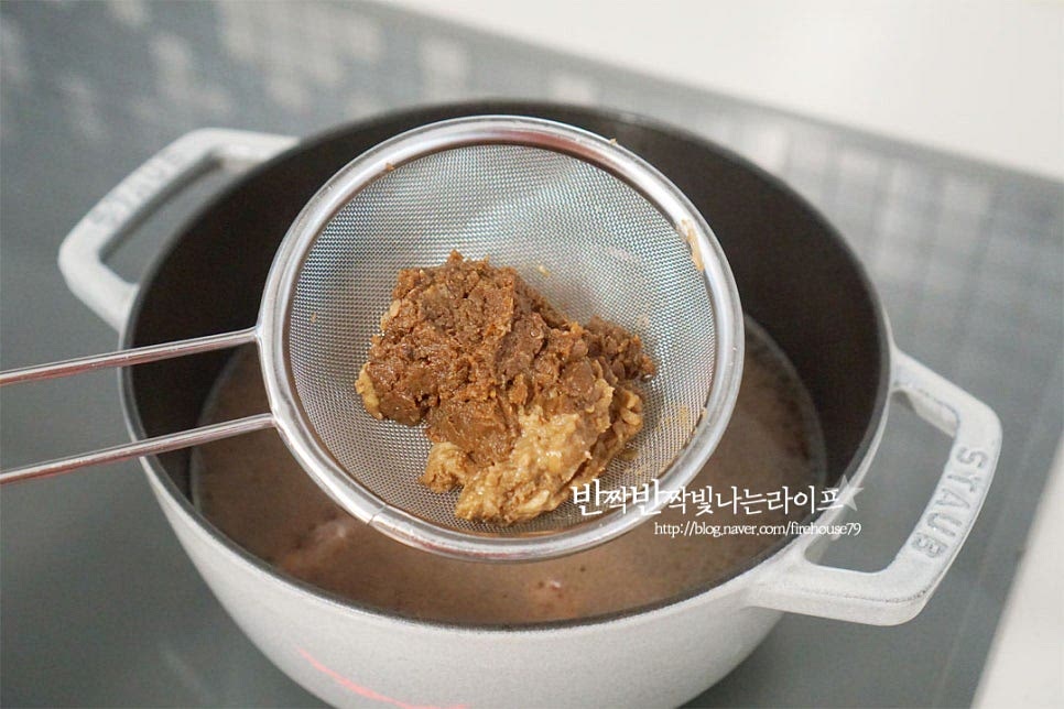 육수가 끓어오르면 된장을 풀어줍니다. 체에 넣고 곱게 풀어주면 보다 깔끔하게 국물맛을 낼 수 있어요. 된장 2 큰 술을 넣어주었는데 짠맛에 따라 간이 다르므로 염도에 맞게 양을 조절하여 주세요.