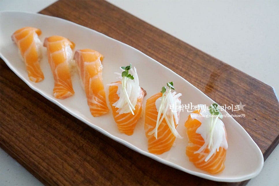 밥 위에 횟감을 올리고 그 위로 소스와 양파, 무순을 곁들여주면 외식하는 것 같은 비주얼 완성이에요. 긴 접시에 먹기 좋게 담아주면 비주얼부터 근사한 초밥만들기 뚝딱~ 두가지 스타일 모두 매력이 있어요. 연어와 특히 잘 어울리는 고추냉이는 취향껏 곁들여 주시면 더 맛있게 즐길 수 있어요. 영상도 같이 담았어요. 취향껏 두툼하게 썰어 먹으니 더 맛이 좋은 것 같아요. 집에서 이렇게 먹음 푸짐하고 맛있게 즐길 수 있어 좋아요. 연어초밥 만들기 맛있게 만들어 드세요^^ 끄읕 !