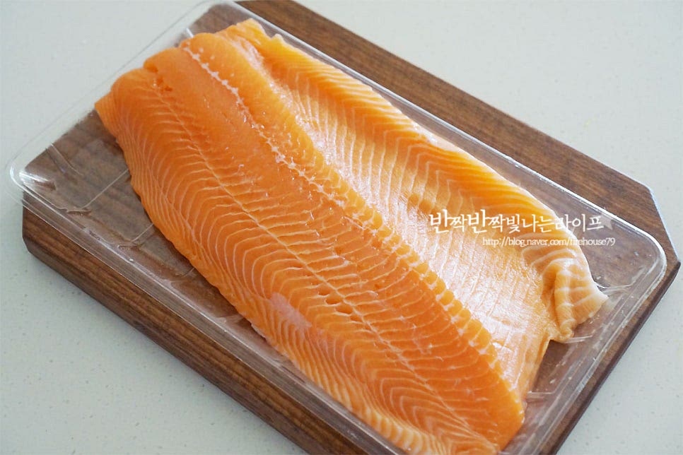 연어필렛을 대형마트에서 구매했어요. 크기가 커서 먹기 좋게 다듬은 뒤 기름기가 많은 부위로 초밥을 만들었답니다. 요리할 부위에 맞추어 큼직하게 잘라준 뒤 청주 50ml를 고르게 뿌려줍니다. 천일염 3 큰 술 정도를 고르게 뿌려준 뒤 30분 실온에 둡니다. 그럼 연어의 수분이 나온답니다. 30분 뒤 얼음 물에 씻어줍니다. 얼음 물에 씻어 살을 만져보면 탄력이 느껴져요. 소금이나 식초, 다시마 등 맛있게 먹는 방법은 다양한데 가장 기본적이고 손쉬운 소금으로 수분을 제거하고 얼음 물에 담가 식감을 살려주었어요. 간단한 방법만으로도 더 맛있게 즐길 수 있답니다. 키친타월로 수분을 꼼꼼하게 제거한 뒤 먹기 좋에 썰어주시면 됩니다. 칼을 어슷하게 기울어 썰어주었어요. 다른 생선보다 집에서 요리하기 손쉬운 게 어떻게 썰어도 식감이 질기거나 하지 않아 저와 같은 자격증 없는 초보 분들도 기호에 따라 먹기 좋은 두께와 크기로 썰어주시면 된답니다.