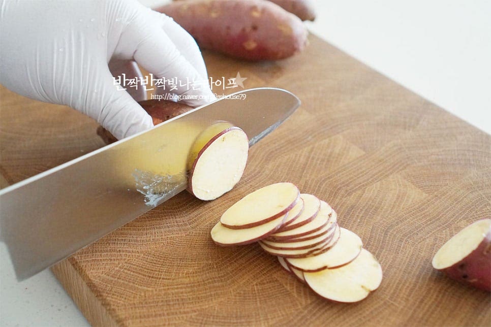 껍질째 썰어줄 것이라 주방 솔로 살살 문질러 흙을 깨끗하게 씻어줍니다. 저와 같이 껍질 그대로 요리해 주셔도 좋고, 칼로 깎아서 만들어도 좋습니다. 동그란 단면 모양 그대로 얇게 편으로 썰어주는데요. 얄팍하게 잘라주면 과자의 식감이 더욱 바삭하게 만들어져요. 일정한 두께로 잘라주면 에프로 조리했을 때 노랗고 균일하게 익어요. 대략 0.3~0.5cm 사이로 잘라줍니다. 바삭한 식감과 서로 달라붙지 않도록 전분을 제거한 뒤 요리해 줍니다. 살살 흔들어 몇 번 헹구어주면 뽀얀 전분이 제거되는데요. 서너 번 흔들어 씻어주었어요. 물에 담가 전분기를 제거할 때는 5분 이내로 담가주어야 단맛이 빠져 싱거워지지 않습니다. 전분을 제거했다면 흐르는 물에 한 번 더 헹구어 체에 밭쳐 물기를 털어줍니다. 키친타월에 올려 물기를 모두 제거해 줍니다. 물기를 꼼꼼하게 없애주세요.