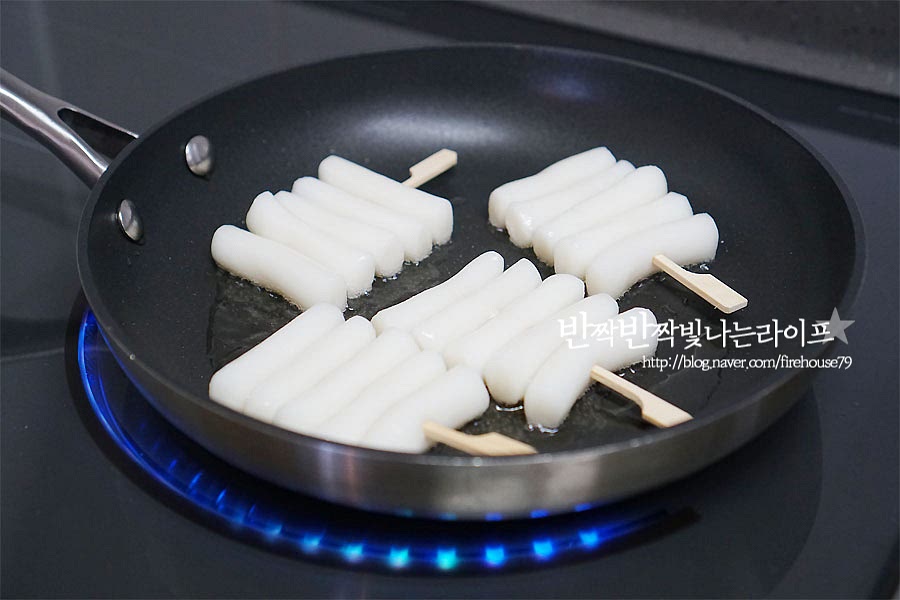 팬에 식용유를 넉넉히 두르고 만들어둔 떡꼬치를 구워줍니다. 튀기듯이 구워주어야 겉의 식감이 바삭바삭하고 속이 쫄깃하게 씹히는 게 더 맛있어요. 앞뒤로 노릇하게 구워줍니다.