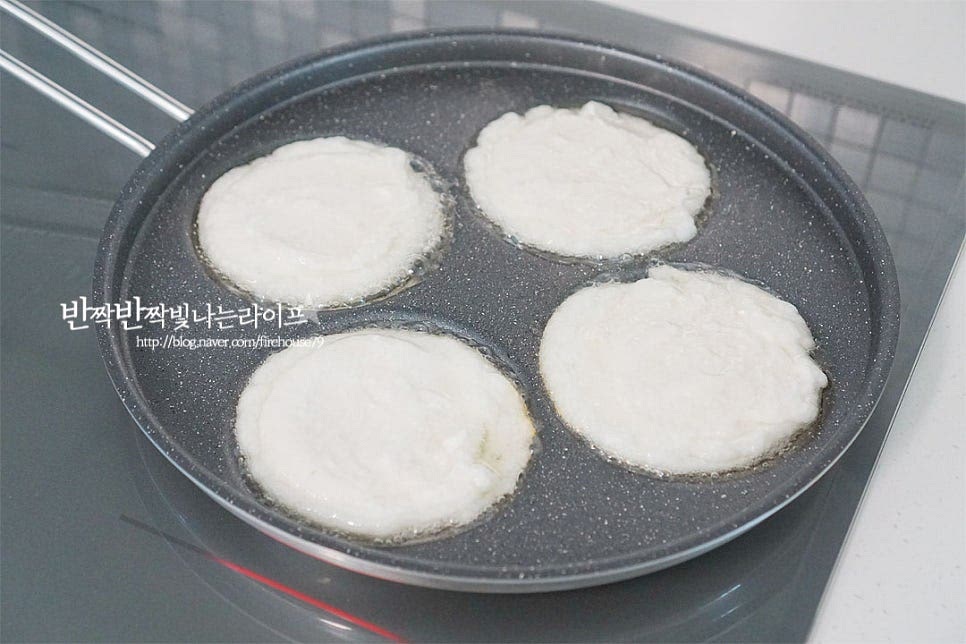 달군 팬에 식용유를 넉넉하게 두르고 반죽을 동글납작하게 올려줍니다. 전을 구울 때 뜨겁게 달군 기름 팬에 차가운 반죽을 올려주면 식감이 더 바삭바삭하면서 속이 쫀득쫀득 부드러워요. 썰어둔 고명도 올려줍니다. 겉 테두리부터 바삭하게 익어가는 게 보이면 뒤집어 구워줍니다. 앞뒤로 노릇하게 구워내면 맛있게 완성입니다.