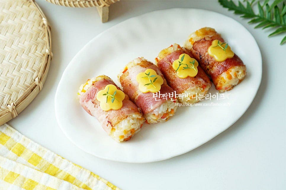 노릇노릇 먹음직스럽게 완성입니다. 치즈로 꽃모양을 만들어 올려주었더니 예쁘게 만들어졌습니다. 베이컨은 바로 구워서 먹어도 맛있지만 주먹밥 말이를 만들어먹으면 짭조름 고소한 맛이 도시락 메뉴나 아이들 한 끼 식사로 먹기도 좋답니다. 치즈나 야채와 같은 재료를 레시피에 활용해 맛있게 만들어드세요. 끄읕 !