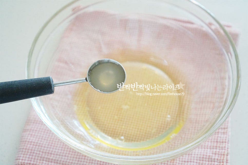 넉넉한 크기의 볼에 흰자를 담고 레몬즙 4g을 넣어줍니다. 레몬즙을 넣으면 단단한 머랭을 만들 수 있습니다. 레몬즙을 넣고 가볍게 풀어줍니다. 잔거품이 올라오면 준비한 분량의 설탕 26g을 세 번에 나누어 넣어가며 머랭을 만듭니다. 거품이 풍성하게 올라오면서 설탕이 섞이면 나머지 1/3분량을 넣고 다시 휘핑하여 섞어주는 과정을 반복합니다. 점점 색이 하얗게 되면서 질감이 쫀쫀해지는 거품이 만들어져요. 거품기 자국이 생기면서 단단해지면 거품기를 살짝 들어봅니다. 뾰족하게 뿔이 생기면서 볼을 뒤집어보았을 때도 붙어서 흘러내지 않는 정도로 단단하게 머랭을 쳐주셔야 수플레팬케이크도 맛있게 폭신폭신해요.