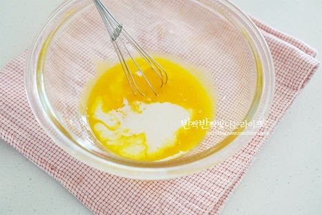 노른자에 비린내를 잡아주기 위해 바닐라익스트랙 1g을 넣고 우유 25g, 소금 두세꼬집을 넣고 섞어줍니다. 잘 섞인 노른자 위로 박력분 35g을 곱게 체에 내려줍니다. 밀가루는 덩어리지만 잘 풀어지지 않으니 체에 내린 뒤 섞어주세요. 날가루와 뭉치는 부분이 없도록 가볍게 섞어줍니다.