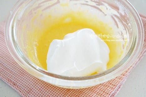 섞어둔 노른자 반죽에 머랭을 한 주걱 덜어서 넣고 섞어줍니다. 한 번에 섞으면 거품이 꺼지기 쉬우므로 소량을 먼저 섞은 뒤 전체적으로 반죽해 줍니다. 섞은 뒤 본 반죽에 넣고 함께 섞어줍니다. 이때 거품이 풍성하게 꺼지지 않도록 주걱을 아래에서 위로 퍼올리듯이 섞어줍니다. 반죽이 묽어지면 지나치게 퍼지거나 부풀어 오름이 잘되지 않으니 섞는 과정 또한 중요합니다.