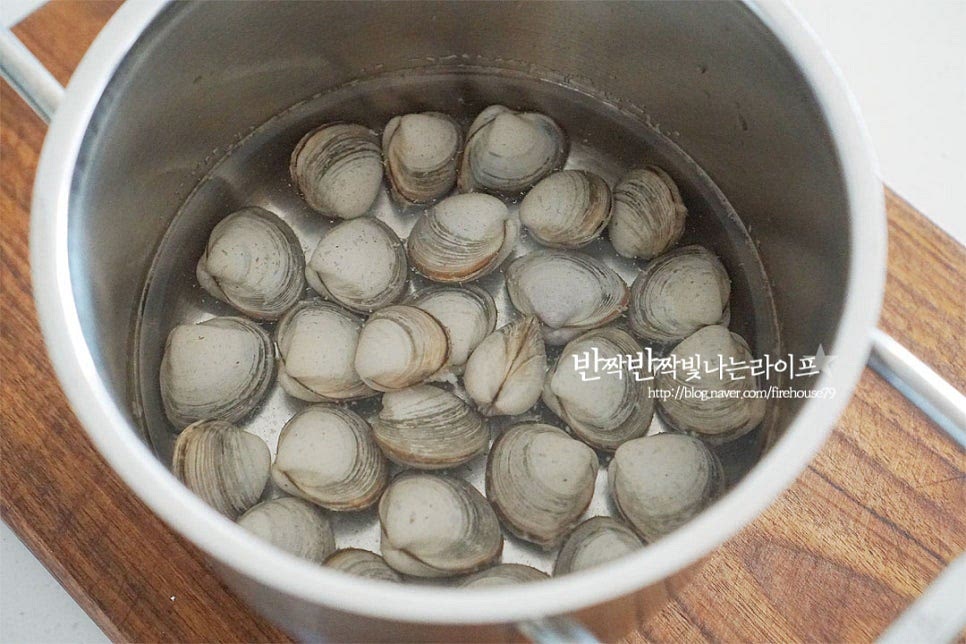 동죽은 물총을 쏜다고 하여 물총조개라고도하는데요. 싱싱한 것은 물총을 쏘며 만져보았을 때 바로 입을 다물면 신선한 상태입니다. 갯벌체험을 하면 가장 많이 잡히기도 하여 바지락만큼이나 친숙한 조개 종류인데요. 모든 조개는 요리하기 전 해감 방법이 가장 중요하죠. 제대로 손질하지 않으면 살을 발라먹다가 이물질이 씹힐 수도 있어 먼저 동죽 해감부터 해줍니다. 깨끗한 물에 가볍게 씻어 스테인리스 볼이나 냄비에 담아줍니다. 물 500ml 정도에 소금 1 큰 술 듬뿍 넣고 바닷물과 같은 짠 소금물을 만들어주어요. 빛을 차단하는 뚜껑이나 검은 비닐, 신문지를 덮어 어둡고 서늘한 곳에 둡니다. 조용하고 어두운 곳에 두면 모래를 잘 뱉어 냅니다. 소금물과 스테인리스가 만나면 산화 반응을 일으켜서 이물질을 더 잘 뱉어내기 때문에 쇠숟가락을 넣기도 하는데요. 스테인리스 냄비에 손질하면 보다 간편하답니다^^ 기본 손질이 된 것이라 3시간 정도 두었는데요. 상태에 따라 4시간에서 반나절 정도 충분히 해감해 주세요. 이물질을 꽤 뱉어 내어서 바락바락 문질러 씻은 뒤 물기를 털어줍니다.