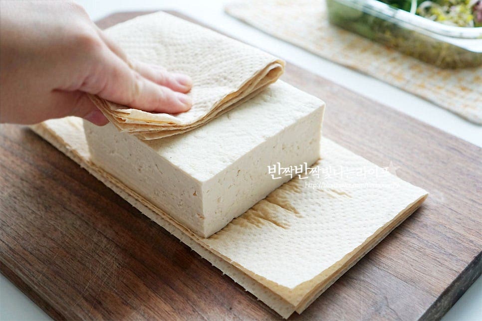 두부구이를 만들기 전에 키친타월로 수분을 꼼꼼하게 제거해 줍니다. 수분이 꽤 많이 나오는 식재료라 수분 제거 과정도 중요해요. 수분을 제거한 뒤 격자무늬로 칼집을 넣어줍니다. 3/4지점까지만 칼집을 넣어줍니다. 젓가락을 양쪽에 두고 칼집을 넣어주면 보다 편해요~